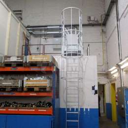 Mezzanine ladder with cage Cage ladder used to access the top of a mezzanine in a facility.